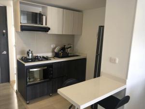 una pequeña cocina con fogones y mesa. en Increible vista al lago, en Paipa