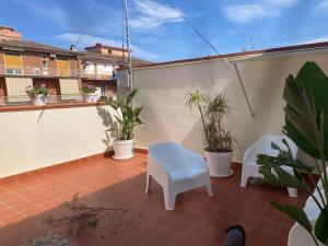 a small balcony with plants and a white chair at Lavica Di Mezzo Apartments in Catania
