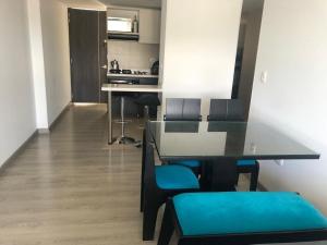 Un comedor con una mesa y sillas azules. en Increible vista al lago, en Paipa