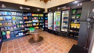 a store aisle with drinks and a small table in the middle at 701 - Flat Temporada em Goiania-proximo ao Parque Areião in Goiânia