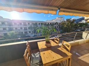 a table and chairs on a balcony with a view of a city at Türkiz Kánaán Apartman in Puerto de Santiago
