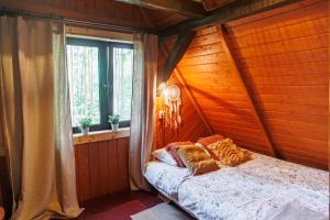 sypialnia z łóżkiem w drewnianym pokoju w obiekcie Frono nad Bugiem - dom na wynajem w mieście Sarnaki