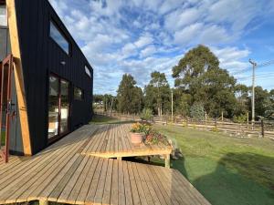 una terraza de madera con un banco en una casa en In Situ Mar, en Pichilemu