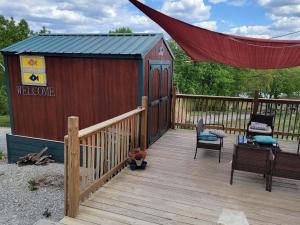 a wooden deck with a shed with a table and chairs at 1 Fish in Warsaw