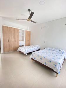 ビリャビセンシオにあるVilla La Bendición Casa Campestreのベッド2台と天井ファン付きの寝室 +16枚の写真