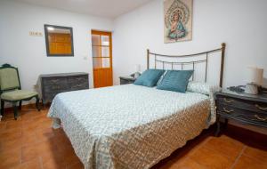 a bedroom with a bed and a chair and a mirror at La Casa del Castillo in Arévalo