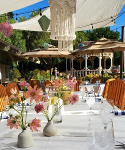 Una mesa blanca con flores en jarrones. en Carmel Valley Lodge, en Carmel Valley