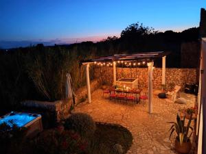 een patio met een pergola met een tafel en stoelen bij Villa Cesarica Novalja in Novalja