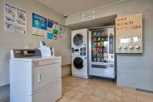 a laundry room with a refrigerator and a washer and dryer at Motel 6-Albuquerque, NM - Carlisle in Albuquerque