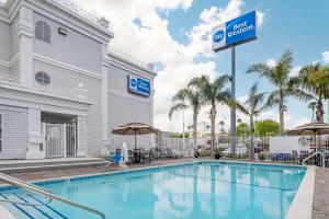 une piscine avec un panneau d'hôtel à côté d'un bâtiment dans l'établissement Best Western Salinas Monterey, à Salinas