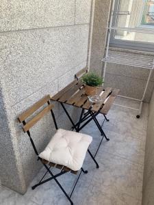 a wooden table and chair next to a wall at El paraíso in Raxó