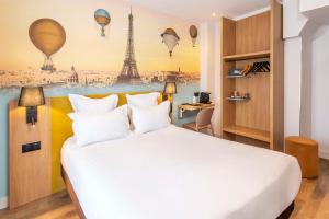a hotel room with a bed and a poster of hot air balloons at Hotel Apolonia Paris Mouffetard, Sure Hotel Collection by Best Western in Paris