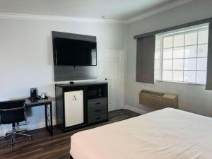 1 dormitorio con 1 cama y TV de pantalla plana en SureStay by Best Western Fresno Central, en Fresno