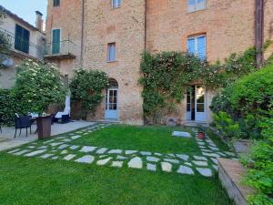 a garden in front of a large brick building at Antico Sipario Boutique Hotel, BW Signature Collection in Paciano
