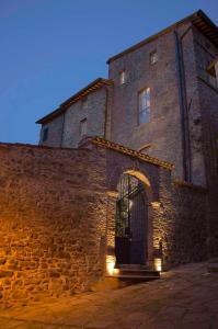 an old stone building with a door and lights at Antico Sipario Boutique Hotel, BW Signature Collection in Paciano