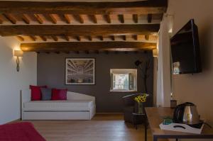 a living room with a white couch and a tv at Antico Sipario Boutique Hotel, BW Signature Collection in Paciano