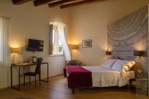 a bedroom with a bed and a desk and a television at Antico Sipario Boutique Hotel, BW Signature Collection in Paciano