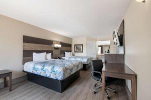 ein Hotelzimmer mit 2 Betten und einem Schreibtisch in der Unterkunft Motel 6 Macon, GA I 475 in Macon