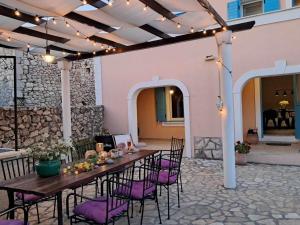 eine Terrasse mit einem Tisch und Stühlen sowie ein Gebäude in der Unterkunft Villa Cesarica Novalja in Novalja