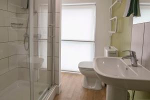 uma casa de banho com um chuveiro, um WC e um lavatório. em Tor Park Hotel, Sure Hotel Collection by Best Western em Torquay
