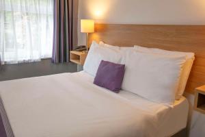 um quarto com uma cama grande e uma almofada roxa em Tor Park Hotel, Sure Hotel Collection by Best Western em Torquay