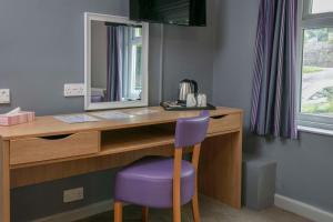 uma secretária com um espelho e uma cadeira roxa em Tor Park Hotel, Sure Hotel Collection by Best Western em Torquay