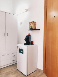 a kitchen with a white refrigerator and a microwave at Monteleone rooms in Palermo