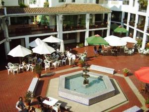 聖地亞哥的住宿－Hermoso Depto en sector alto de Las Condes，庭院设有喷泉、桌子和遮阳伞