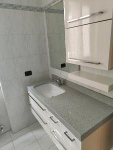 a white bathroom with a sink and a mirror at House curti in Sorico +30 photos