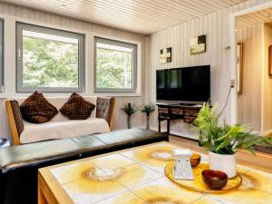 uma sala de estar com um sofá e uma televisão em Holiday home Hadsund CXLVII em Hadsund