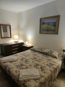 a bedroom with a bed and a dresser and a picture at House curti in Sorico