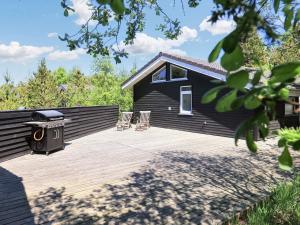 una terraza con 2 sillas y una parrilla en una casa en 6 person holiday home in lb k, en Ålbæk
