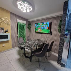 una sala da pranzo con tavolo e TV a parete di maison Samkam57 a Florange