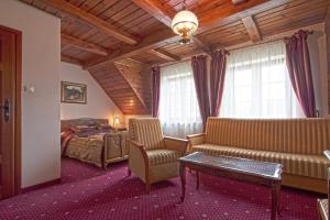 1 dormitorio con cama, sofá y mesa en Dworek Gawra, en Białowieża