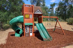 um parque infantil com um escorrega e uma estrutura de jogos em Scenic Serenity 50acres -Hot tub -Game room -Playground em Oakhurst