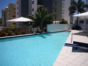 a large blue swimming pool in front of a building at Rovera Apartments in Maroochydore