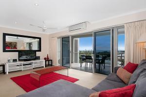 a living room with a couch and a television and a table at Rovera Apartments in Maroochydore
