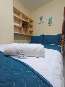 a bedroom with a bed with blue and white sheets at Hotel Cuencano Hogar in Cuenca +6 photos