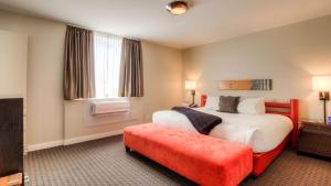 Cette chambre d'hôtel comprend un grand lit et un banc rouge. dans l'établissement Adara Hotel, à Whistler