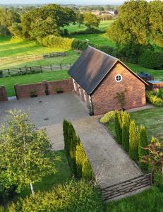uma vista aérea de um edifício de tijolos num campo em Cheshire Retreat em Middlewich