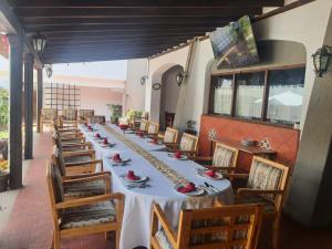 uma longa sala de jantar com uma longa mesa e cadeiras em Villas Arqueologicas Cholula em Cholula