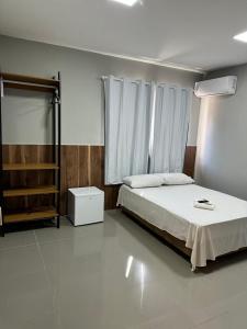 a bedroom with a bed and a dresser in it at Hotel Casa Grande in Governador Valadares +11 photos