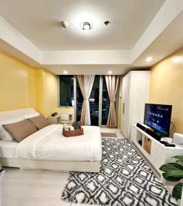 1 dormitorio con 1 cama blanca grande y TV de pantalla plana en Staycation at Azure by Mariane, en Manila