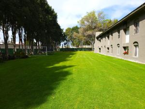 a large green lawn next to a building at Villas Arqueologicas Cholula in Cholula