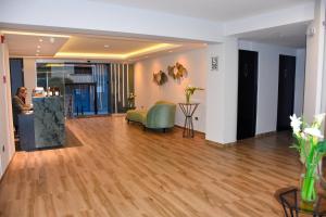 a living room with a green couch and wood floors at Muña Hotel Andahuaylas in Andahuaylas