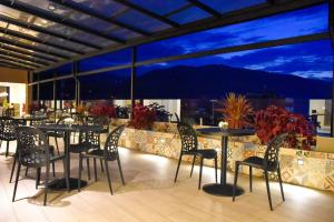 un restaurante con mesas y sillas y vistas a la montaña en Muña Hotel, en Talavera