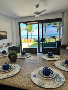 a table with plates on it with a view of the ocean at Ekoara Residence bangalô 07 in Porto De Galinhas