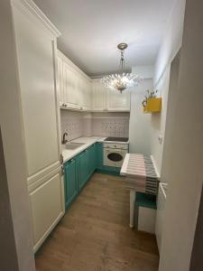 uma cozinha com armários verdes e uma mesa em CAELIA Residence ap 2 camere em Mamaia