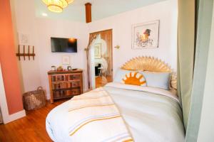 a bedroom with a large white bed with a wooden headboard at Bohemian Bungalow in St Augustine! in Saint Augustine