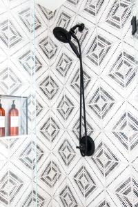 a black shower head hanging on a white wall at Bohemian Bungalow in St Augustine! in St. Augustine